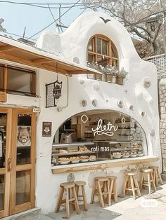 the outside of a restaurant with lots of counter space and stools in front of it