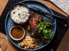 a blue plate topped with meat and rice