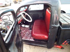 the interior of an old car is red and black