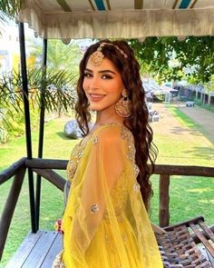 a woman in a yellow dress standing on a porch