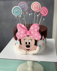 a minnie mouse cake with lollipops on top