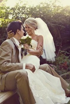 a bride and groom are sitting on a bench