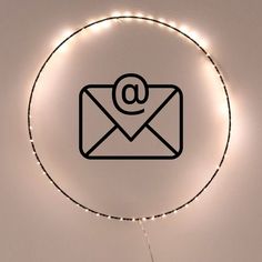 an email envelope is lit up in the middle of a circle with string lights around it