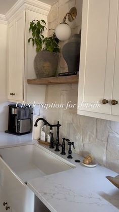 a kitchen with white cabinets and marble counter tops