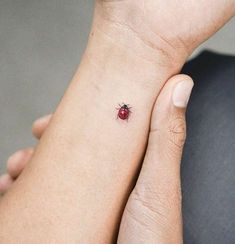 a ladybug tattoo on the left wrist