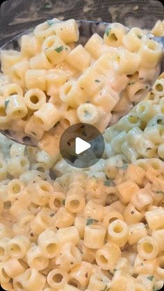 macaroni and cheese being stirred with a spoon