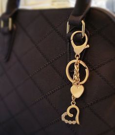 "Instantly add flair and pizzazz to your bag with this gold or nickel bag charm. Features faux diamond accents, two hearts, attachable lobster claw and removable keychain ring. Show your love for fashion, or, show your love for your loved ones with a gift to your spouse, boyfriend, girlfriend, family member, friend, or your bag! Choose from two finishes: Gold and Nickel. ~ Attachable to your bag with the lobster claw clasp ~ Lobster claw clasp can connect to a piece of hardware with a thickness Elegant Gold Bag Charm As Gift, Gold Bag Charm With Lobster Clasp As Gift, Designer Gold Bag With Logo Charm, Gold Logo Charm Bag Charm, Luxury Bag Charm With Keychain, Nickel Allergy, Steel Chain, Handbag Charms, Two Hearts