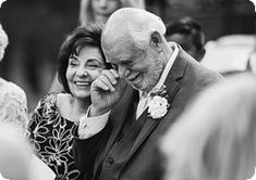 an older man is talking on the phone with a younger woman in front of him