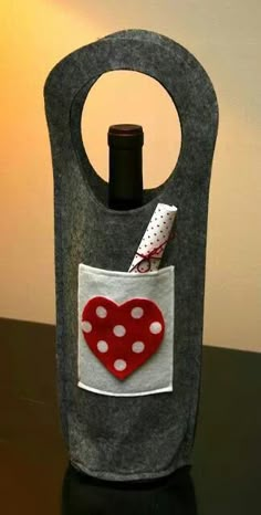 a wine bottle holder with a red heart in the pocket and polka dots on it