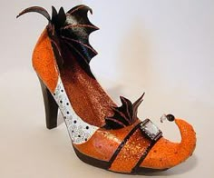 an orange shoe with black and white designs on the bottom, featuring a dragon's tail