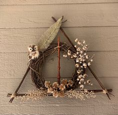 a harry potter inspired wreath on the side of a building with dried flowers and leaves