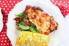 grilled chicken, corn on the cob and salad