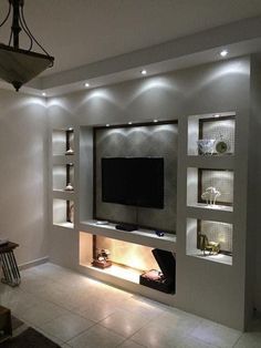 a modern living room with built - in shelving units and lights on the wall