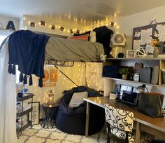 a dorm room with two bunk beds and a desk in the corner, lights strung from the ceiling