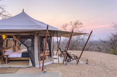 a tent set up on top of a sandy hill