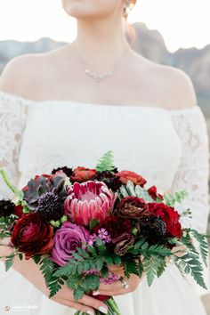 a woman holding a bouquet of flowers in her hands