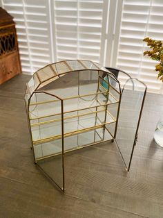 a glass display case sitting on top of a wooden table next to a vase filled with flowers