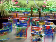 there are many different colored glass blocks on the table and one is standing in front of them