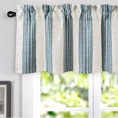 a kitchen window with blue and white striped curtains