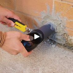 a person using a corkscrew to fix a hole in the wall with a screwdriver