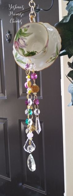 a plate hanging from the side of a door with beads and charms attached to it