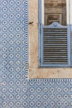 an old window with blue and white tiles on it