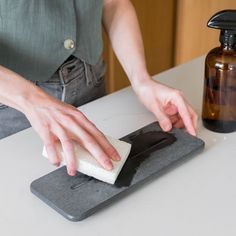 a person using a sponge to clean a counter top