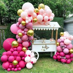 pink and gold balloons are on display in the yard