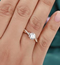 a woman's hand with a diamond ring on top of her finger and an engagement band