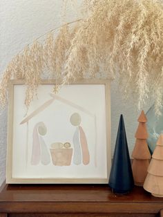 a christmas scene with three trees and a nativity scene on a mantle in front of a white wall