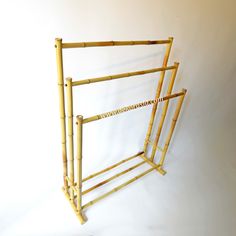 a bamboo rack with three sections for storing clothes and other things on the wall, against a white background