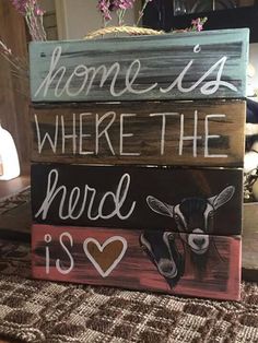 three wooden signs with the words home is where the herd is painted on each one