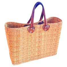 a brown wicker bag with leather handles on a white background and clippings