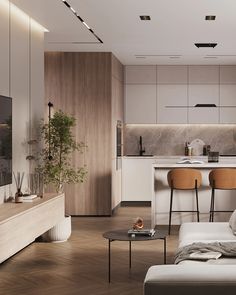 a living room filled with furniture next to a kitchen and dining area on top of a hard wood floor