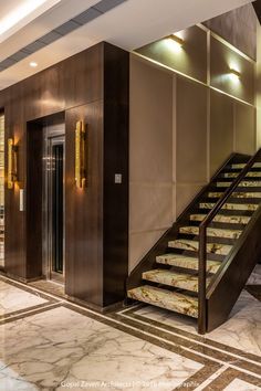 an elegant lobby with marble steps and gold trim on the walls, along with glass doors