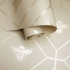 the wall paper has bees on it and is white with silver foiled details, as well as a light fixture