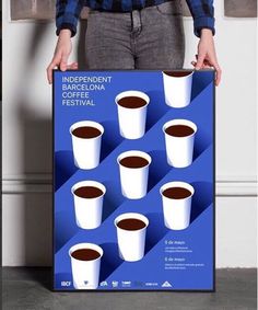 a person holding a poster with coffee cups on it