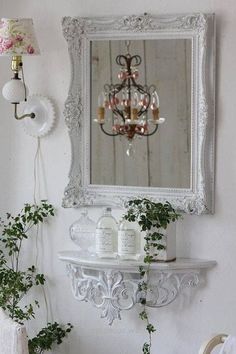 a mirror hanging on the wall next to a potted plant