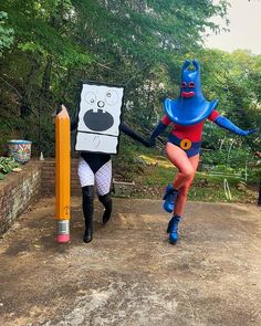 two people in costumes walking down a dirt road