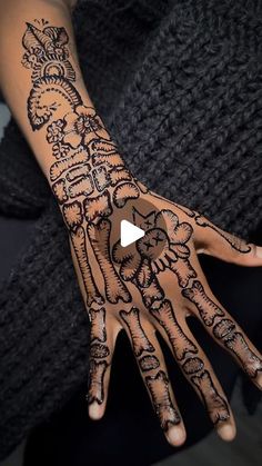 a woman's hand with henna tattoos on it