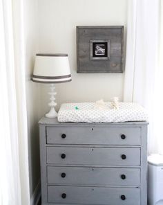 a baby crib in the corner of a room next to a lamp and window