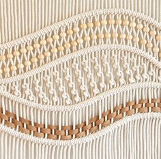 three pieces of woven material with wooden beads on them, all in white and brown