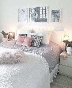 a bed with white sheets and pink pillows in a small room next to two pictures on the wall