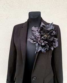 a black jacket with a flower on the lapel