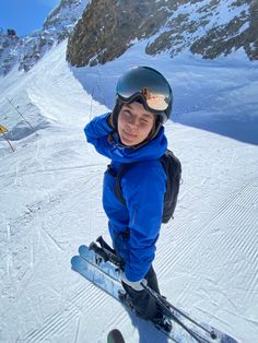 a young boy is standing on skis in the snow