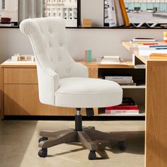 a white office chair sitting in front of a desk with books on top of it