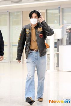 a man wearing a face mask while walking through an airport