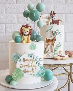 there is a birthday cake with balloons and animals on the top, along with other decorations