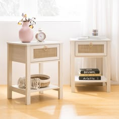 two white nightstands with books and a pink vase on one side, sitting next to each other