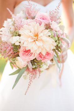 a bridal holding a bouquet of pink and white flowers